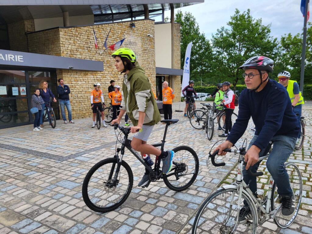 Cyclistes en tenue de sécurité devant un bâtiment, prêts à partir pour une balade ou compétition.