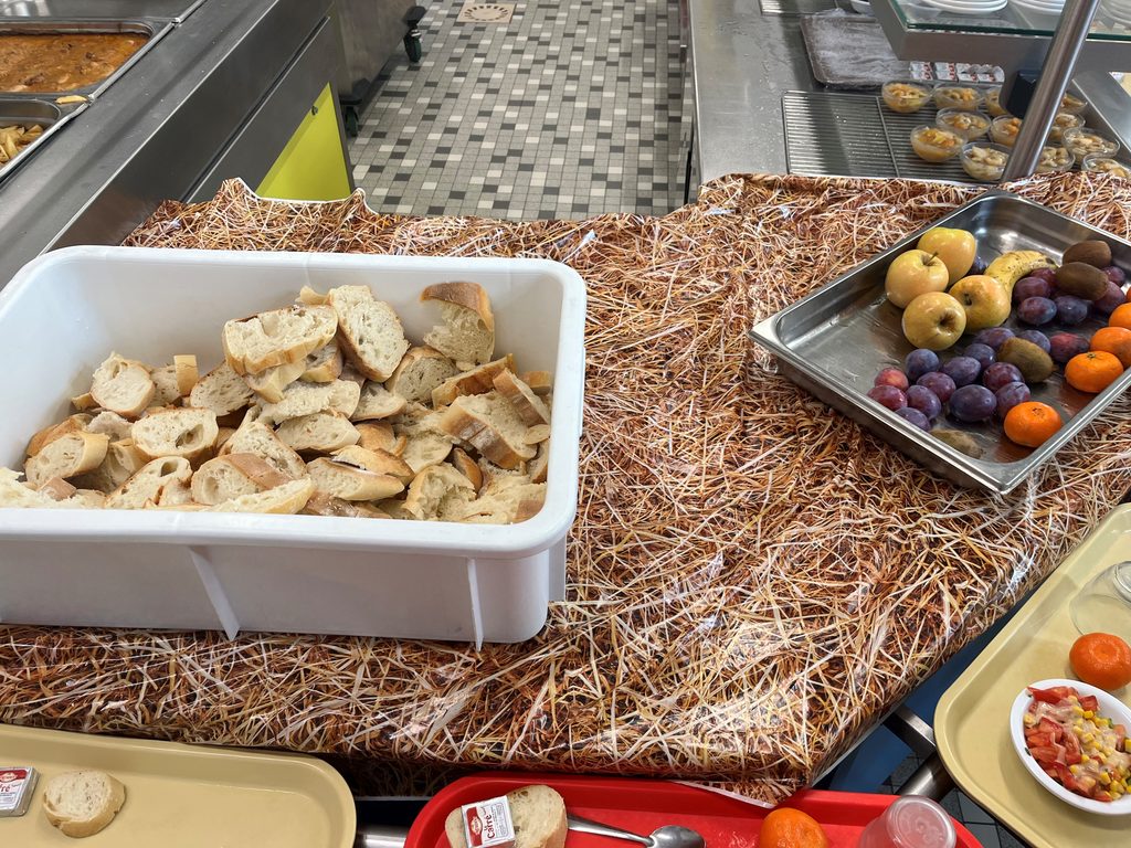 Assiette de pain grillé, fruits frais et snacks sur lit de paillettes comestibles, buffet varié.