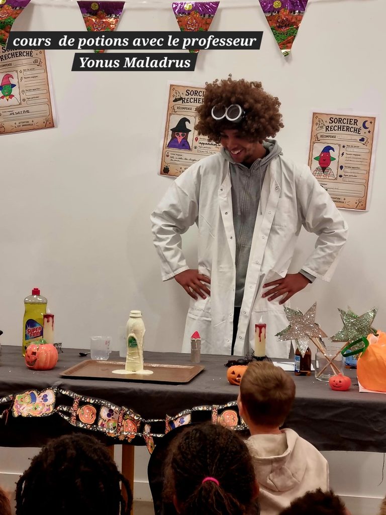 Un professeur, Yonus Maladrus, donne un cours de potions magique à des enfants, ambiance Halloween.