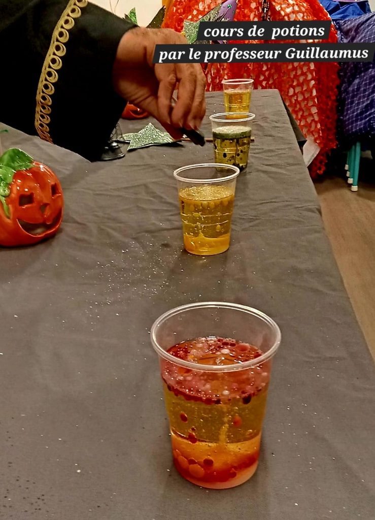 Cours de potions : trois gobelets avec potions colorées, animé par le professeur Guillaumus, ambiance festive et décorativ